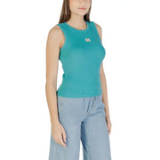 Women wearing teal ribbed tank top with chest patch and light blue wide-leg pants