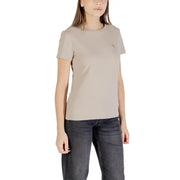 Beige Guess Active women’s short-sleeve crewneck T-shirt with subtle design and dark jeans