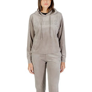 Women wearing taupe velvet tracksuit with hooded top and elasticated pants for Guess Active