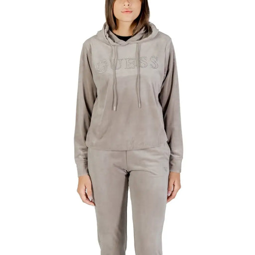 Women wearing taupe velvet tracksuit with hooded top and elasticated pants for Guess Active