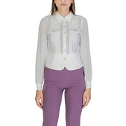 Women wearing white long-sleeved button-up blouse with pleats and purple trousers