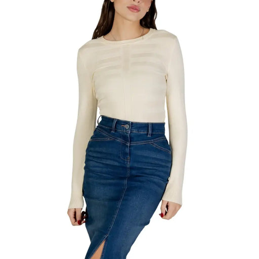 Cream-colored long sleeve round neck viscose knit top with subtle ribbed detailing across the chest