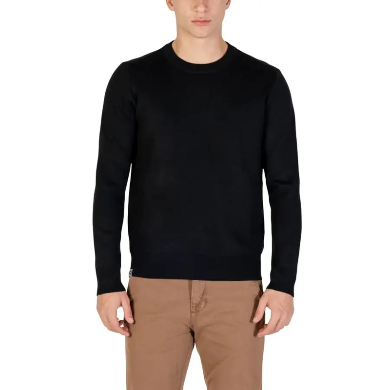 Black crew neck sweater with ribbed cuffs and hem, likely made of cotton or wool.