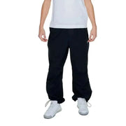 Junger Junge in Karl Kani Herrenhose, urbaner Stil, weißes Hemd, schwarze Hose