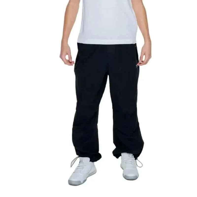 Junger Junge in Karl Kani Herrenhose, urbaner Stil, weißes Hemd, schwarze Hose